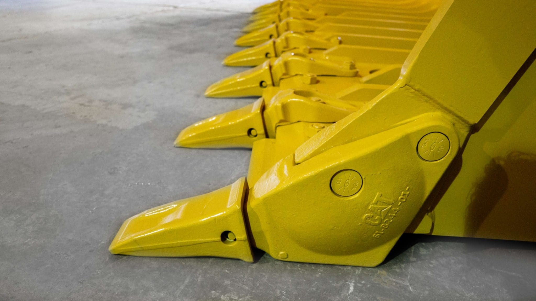 Close-up of Dymax skeleton rock bucket showing bolt-on tooth and adapter assembly for wear protection