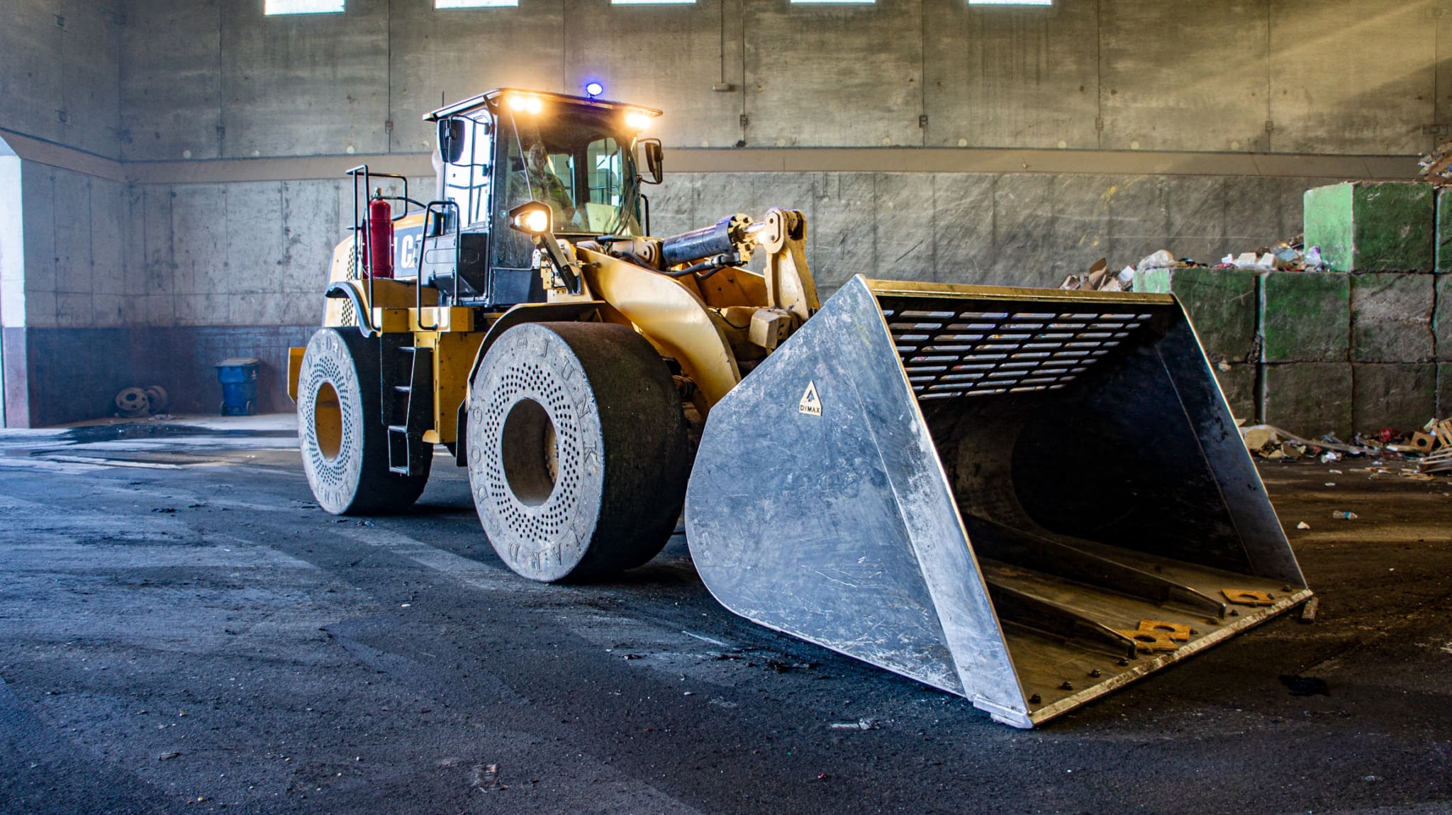 Cat wheel loader fitted with a Dymax refuse bucket at a waste transfer station