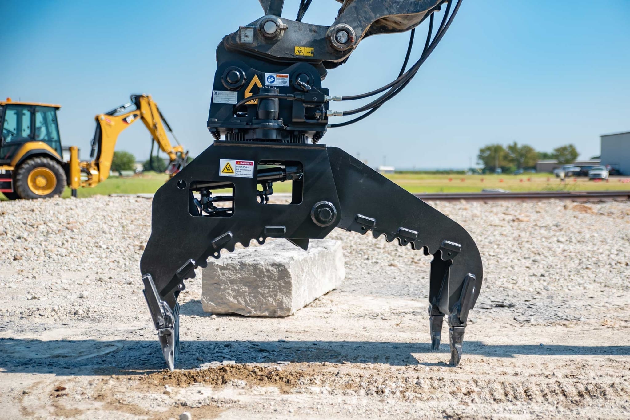 Rotating stone block grapple attachment for handling cut dimension stone with hydraulic excavator in quarry setting