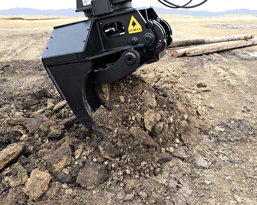 IronClaw digging into soil / working in dirt Dymax IronClaw excavator claw breaking up soil and raking dirt on jobsite