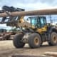 heel loader handling utility poles with a Dymax pole handling fork attachment