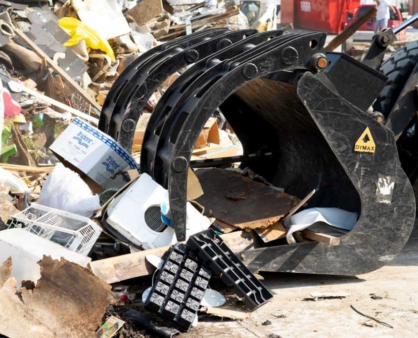 dymax-grapple-bucket-recycling-waste-handling Grapple bucket handling scrap and waste material in a recycling facility