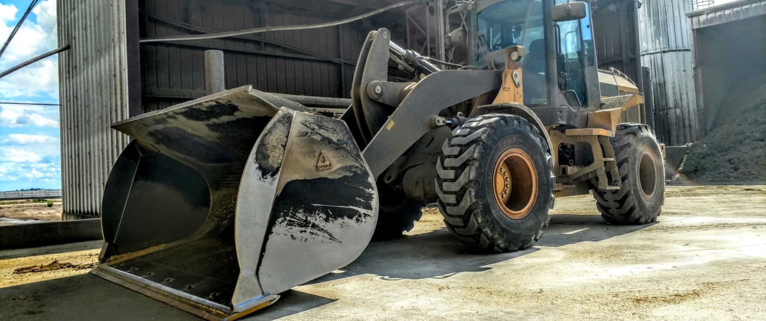 Wheel Loader Using Feedyard Light Material Bucket Wheel loader equipped with a Dymax feedyard light material bucket, ready to load